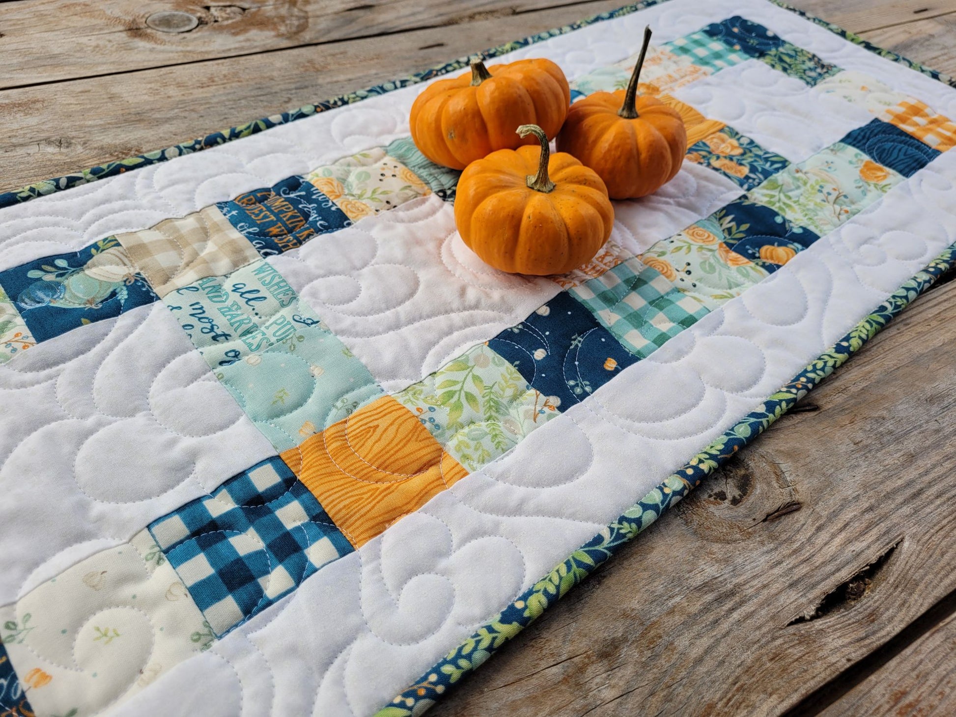 Quilted table runner with harvest pumpkins