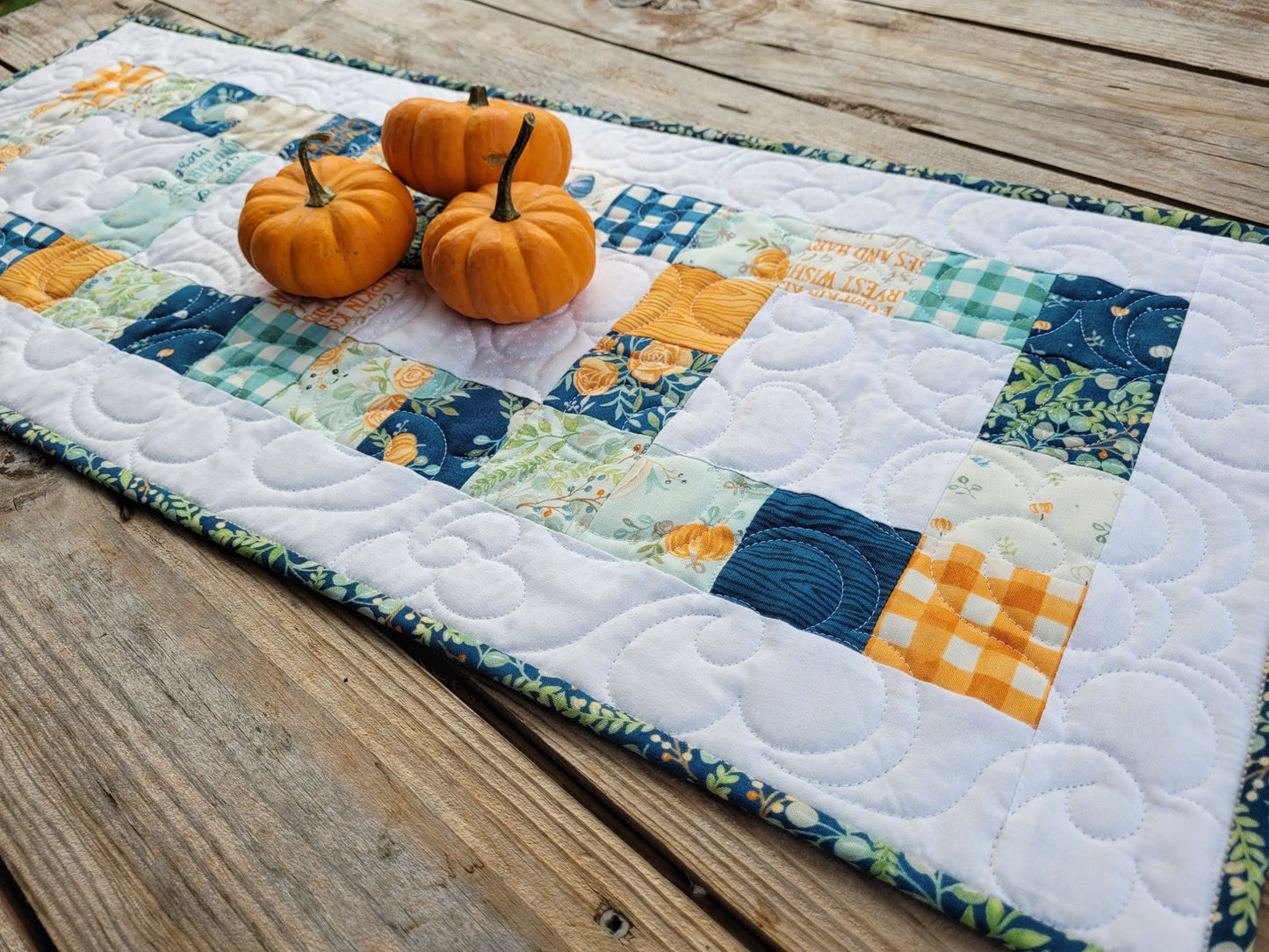 Quilted table runner with harvest pumpkins