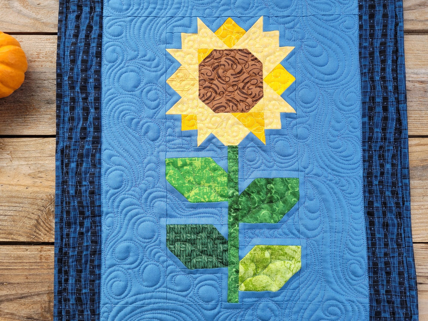 Sunflower patchwork quilt showing detailed stitching.