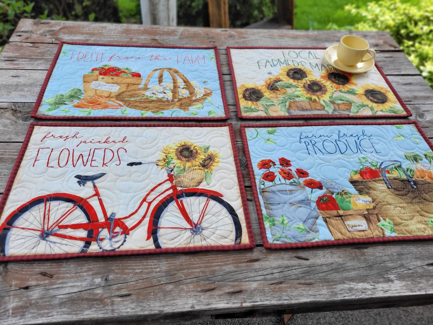 four quilted placemats in produce and flowers farm market theme prints