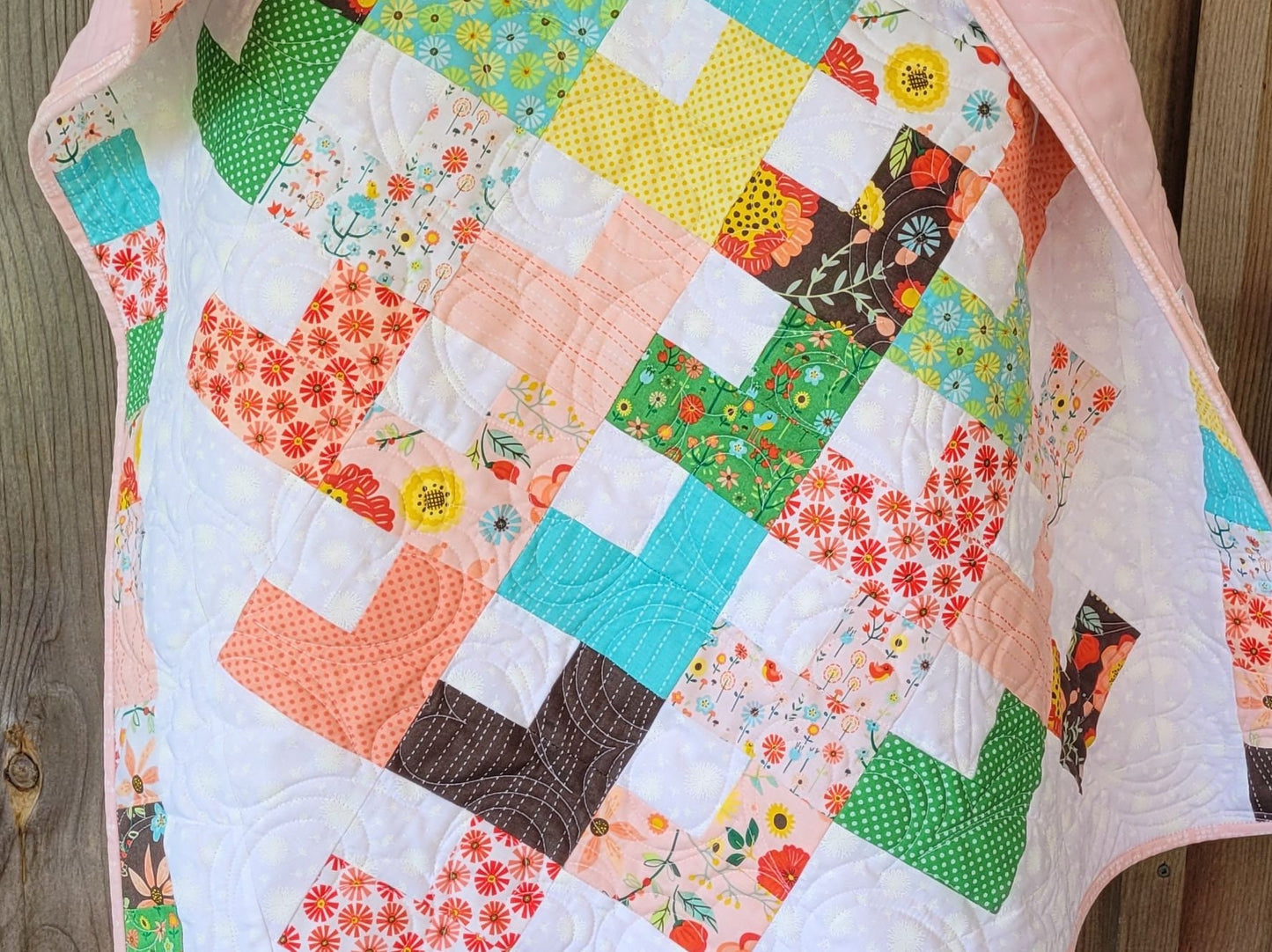close up detail of patchwork hearts on baby girl quilt