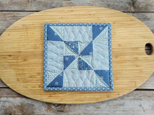 quilted hot mat in steel blue fabric with pinwheel patchwork design
