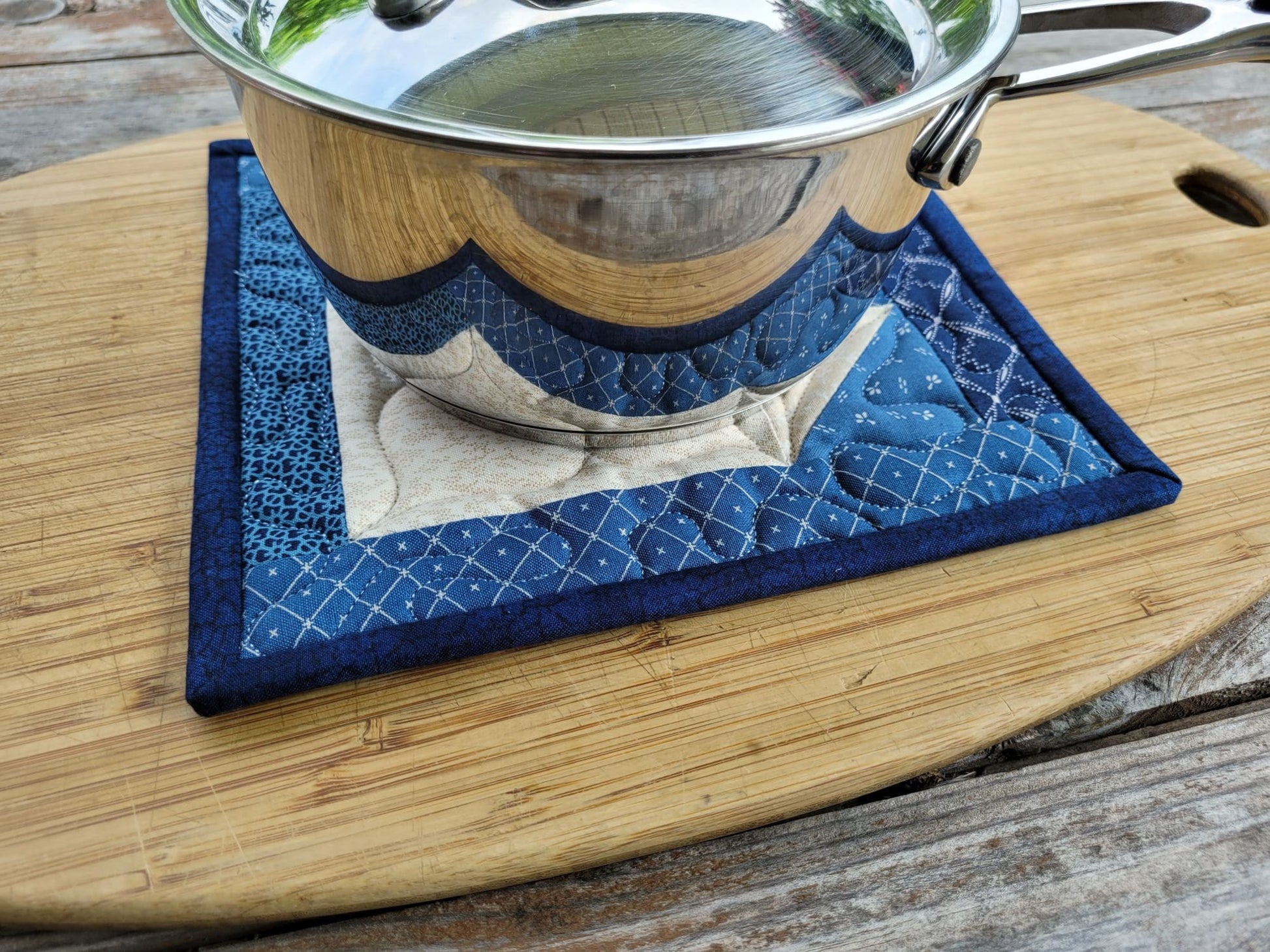 quilted potholder shown under small size saucepan.