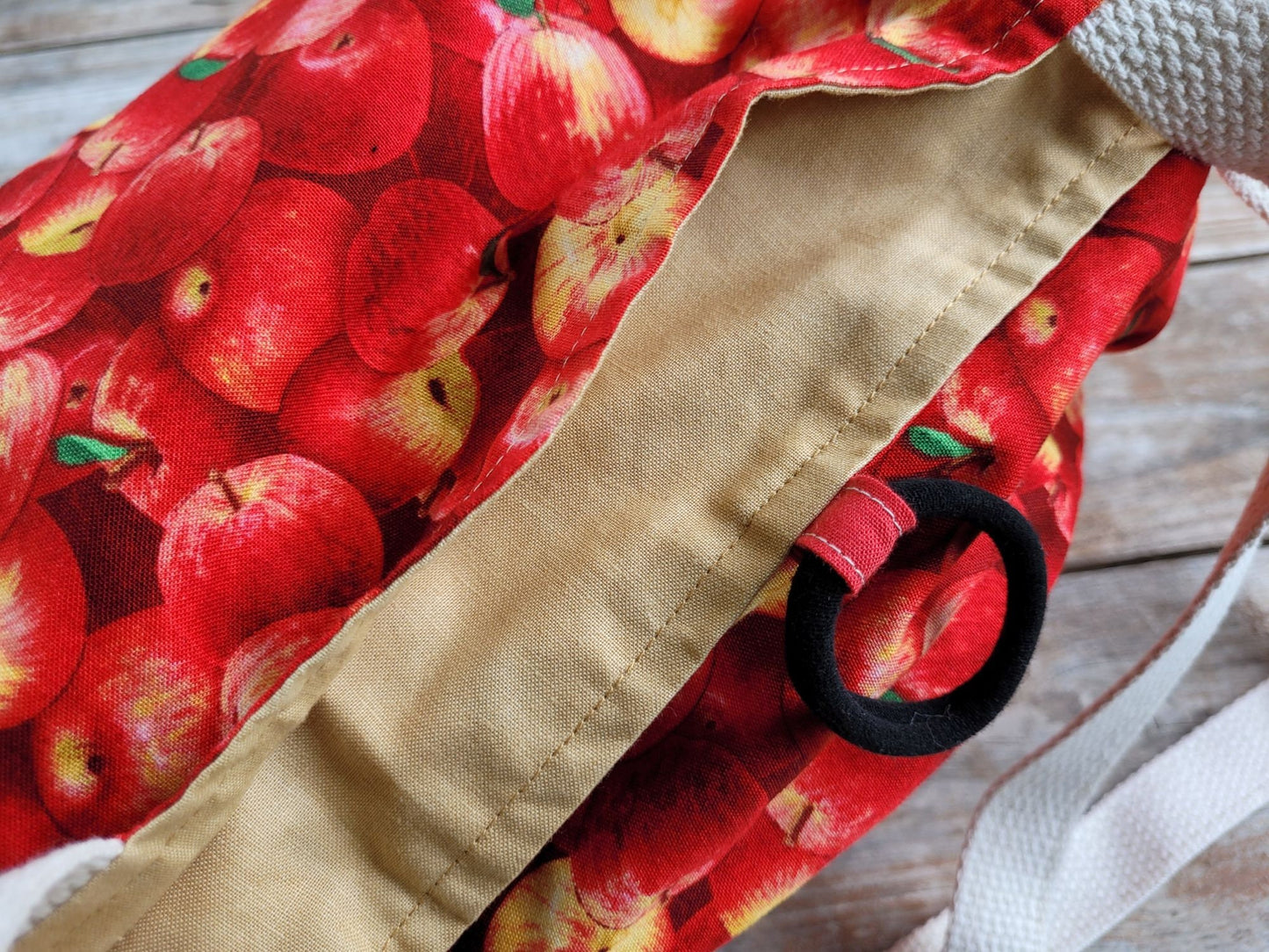 showing red apple fabric detail and sturdy elastic closure of tote bag